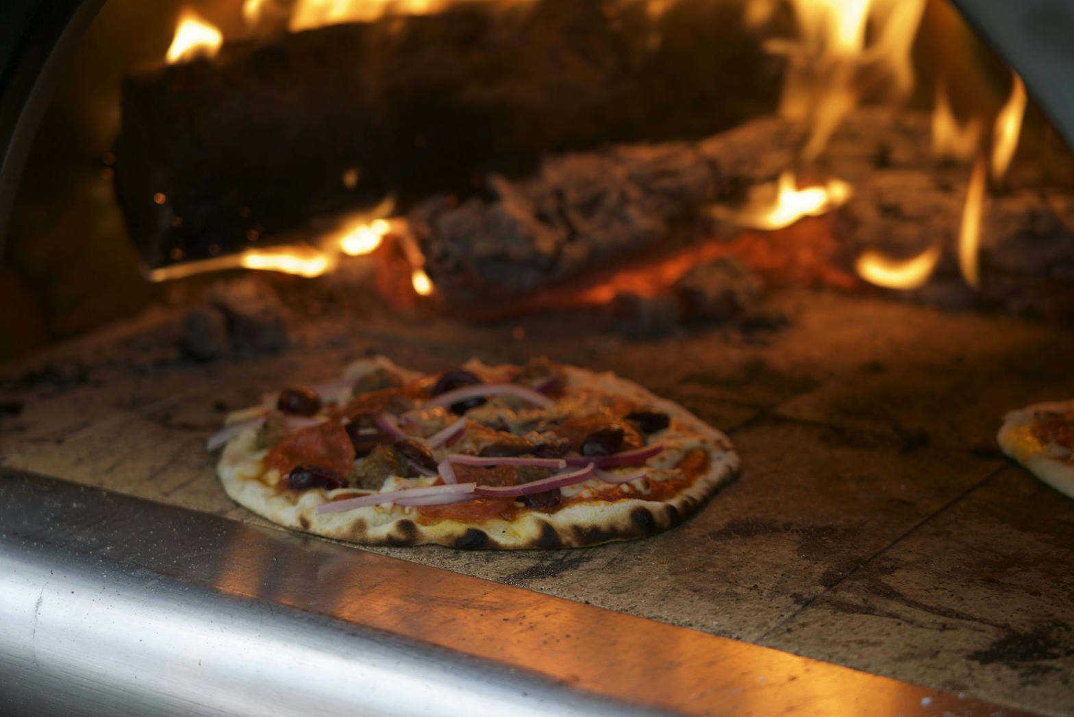 Pizza som bakas i vedeldad ugn
